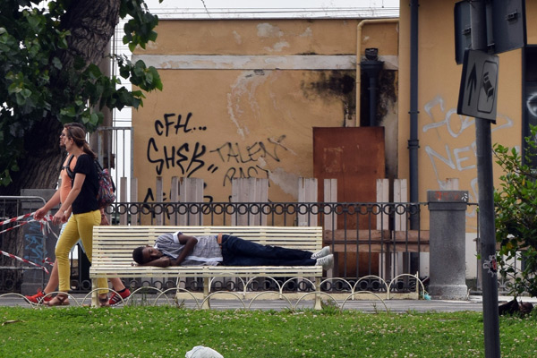 A young migrant sleeps on a bench outside the railway station in Catania, Sicily. JRS Italy known locally as Centro Astalli provides services to asylum seekers in Catania on a daily basis. Credit: JRS Europe/ Oscar Spooner
